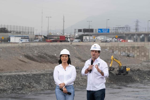 Peru's president-elect for the Fuerza Popular party, Keiko Fujimori (L), listens to the mayor of Lima Sergio Reggiardo (R) during a cleaning and desilting operation on the Rimac river as a preventive measure against the El Niño phenomenon, in Lima on July 9, 2026. (Photo by Ernesto BENAVIDES / AFP)