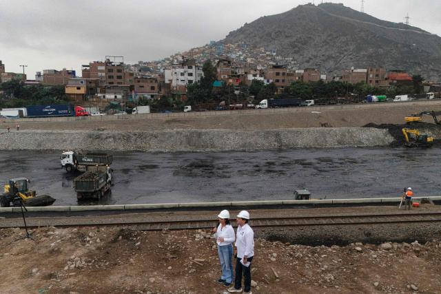 Peru's president-elect for the Fuerza Popular party, Keiko Fujimori (L), stands next to the mayor of Lima Sergio Reggiardo (R) during a cleaning and desilting operation on the Rimac river as a preventive measure against the El Niño phenomenon, in Lima on July 9, 2026. (Photo by Ernesto BENAVIDES / AFP)