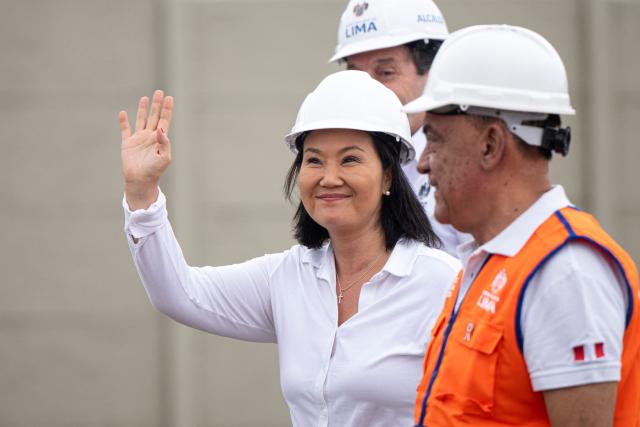 Peru's president-elect for the Fuerza Popular party, Keiko Fujimori (C), waves next to the mayor of Lima Sergio Reggiardo (back)) during a cleaning and desilting operation on the Rimac river as a preventive measure against the El Niño phenomenon, in Lima on July 9, 2026. (Photo by Ernesto BENAVIDES / AFP)