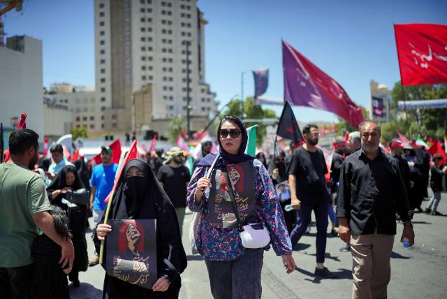 Mourners gather on a street ahead of the funeral procession of Iran's slain supreme leader Ali Khamenei and members of his family before his burial at the Shrine of Imam Reza, Iran's most revered place of worship, in Mashhad on July 9, 2026. Calling for revenge and rejecting any compromise with the West, Iranians loyal to the Islamic republic braved sweltering heat on July 9 to mass for the burial of supreme leader Ali Khamenei in his hometown of Mashhad. (Photo by AFP) / 