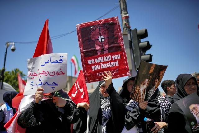 Mourners hold portrait of Israeli Prime Minister Benjamin Netanyahu with a target as they gather on a street ahead of the funeral procession of Iran's slain supreme leader Ali Khamenei and members of his family before his burial at the Shrine of Imam Reza, Iran's most revered place of worship, in Mashhad on July 9, 2026. Calling for revenge and rejecting any compromise with the West, Iranians loyal to the Islamic republic braved sweltering heat on July 9 to mass for the burial of supreme leader Ali Khamenei in his hometown of Mashhad. (Photo by AFP) / 