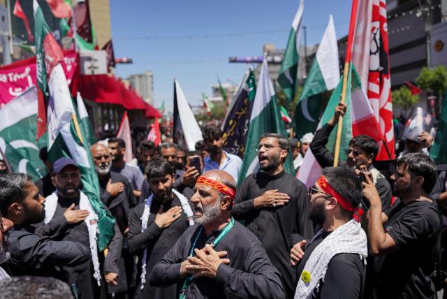 People mourn as they gather on a street ahead of the funeral procession of Iran's slain supreme leader Ali Khamenei and members of his family before his burial at the Shrine of Imam Reza, Iran's most revered place of worship, in Mashhad on July 9, 2026. Calling for revenge and rejecting any compromise with the West, Iranians loyal to the Islamic republic braved sweltering heat on July 9 to mass for the burial of supreme leader Ali Khamenei in his hometown of Mashhad. (Photo by AFP) / 