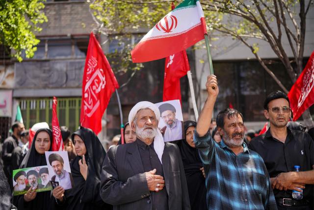Mourners gather on a street ahead of the funeral procession of Iran's slain supreme leader Ali Khamenei and members of his family before his burial at the Shrine of Imam Reza, Iran's most revered place of worship, in Mashhad on July 9, 2026. Calling for revenge and rejecting any compromise with the West, Iranians loyal to the Islamic republic braved sweltering heat on July 9 to mass for the burial of supreme leader Ali Khamenei in his hometown of Mashhad. (Photo by AFP) / 