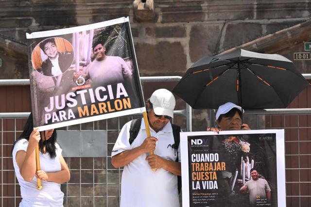 Family members and friends of five security guards who disappeared in mid-June on the high seas hold signs during a sit-in to demand the government to intensify their search, outside the Carondelet Palace, in Quito on July 9, 2026. (Photo by Rodrigo BUENDIA / AFP)