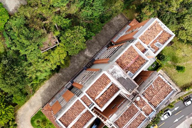 This aerial view shows the ruins of a property (L) belonging to former Colombian National Team goalkeeper Rene Higuita in the El Poblado neighborhood of Medellin, Colombia, on July 9, 2026. A Colombian court on July 9 ordered the seizure of a property belonging to former footballer Rene Higuita after concluding that funds from Pablo Escobar's cartel were used to purchase the house. (Photo by Diego Botero / AFP)