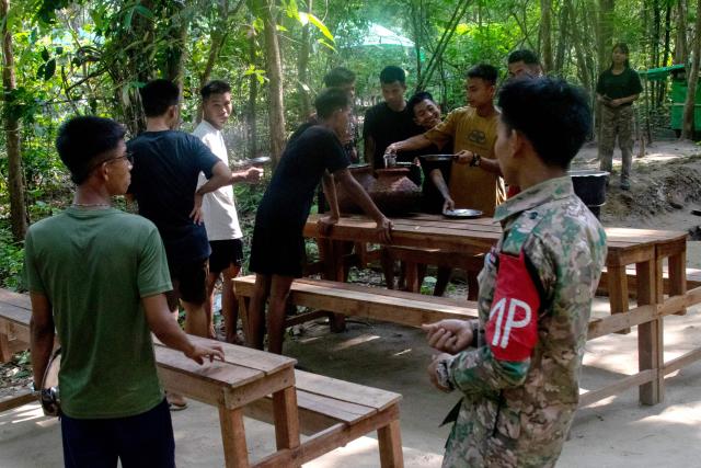 This photo taken on May 19, 2026 show members of the Mandalay People's Defence Forces (MDY-PDF), preparing for lunch after their training session at a secret training camp in an undisclosed location in Myanmar's Saging Region. A civil war erupted after the country's military ousted the elected government of Aung San Suu Kyi in a 2021 coup and cracked down on anti-coup protests, prompting pro-democracy activists to take up arms against the junta, which was already battling powerful ethnic armed groups in decade-long conflicts. (Photo by AFP) / TO GO WITH: Myanmar-war-democracy-fighters