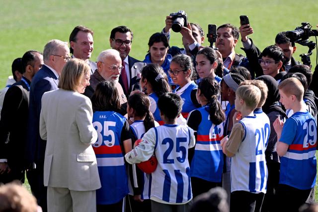 Indian Prime Minister Narendra Modi (C) and Australia’s Prime Minister Anthony Albanese (L) talk to children during a visit to the Melbourne Cricket Ground (MCG) on July 10, 2026. (Photo by WILLIAM WEST / AFP)