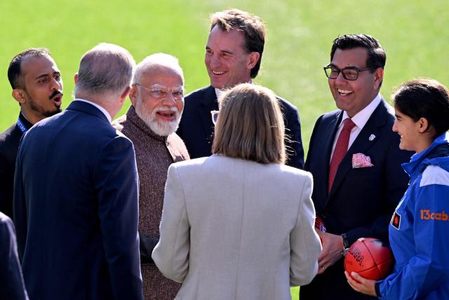 Indian Prime Minister Narendra Modi (3rd L) and Australia’s Prime Minister Anthony Albanese (2nd L) react as they talk with officials during a visit to the Melbourne Cricket Ground (MCG) on July 10, 2026. (Photo by WILLIAM WEST / AFP)