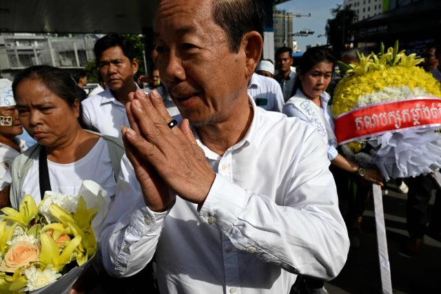 Rong Chhun (C), an advisor of the Nation L Power Party, greets people as he attends a prayer for former prominent Cambodian critic Kem ley during the 10th anniversary of his murder at a gasoline station in Phnom Penh on July 10, 2026. (Photo by TANG CHHIN Sothy / AFP)