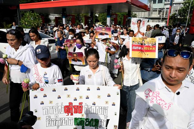 Cambodians and trade unions prepare to march as they carry images of former prominent Cambodian critic Kem ley during the 10th anniversary of his murder at a gasoline station in Phnom Penh on July 10, 2026. (Photo by TANG CHHIN Sothy / AFP)