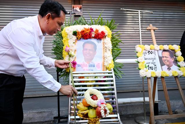 Director of Operations of Cambodian League for the Promotion and Defence of Human Rights (LICADHO) Am Sam Ath places flowers in front of an image of former prominent Cambodian critic Kem ley during the 10th anniversary of his murder at a gasoline station in Phnom Penh on July 10, 2026. (Photo by TANG CHHIN Sothy / AFP)