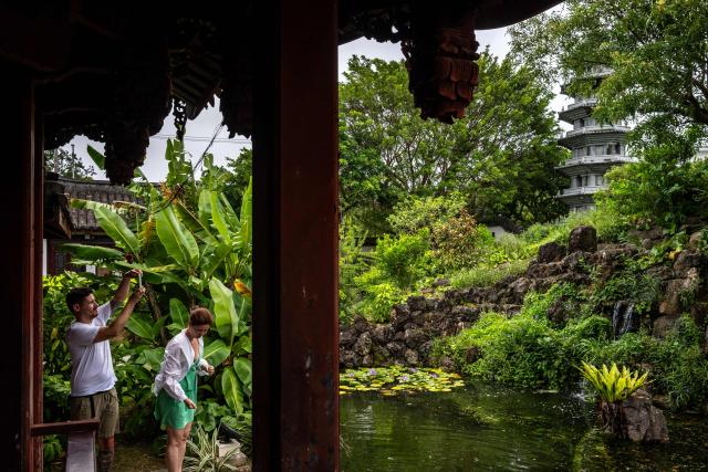 Tourists take pictures at the Fukushuen Garden in Naha, the capital city of Okinawa Prefecture, on July 10, 2026. (Photo by Philip FONG / AFP)
