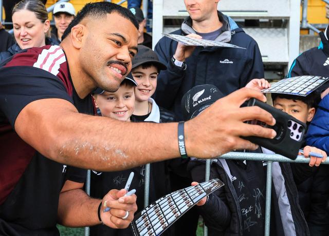 New Zealand's Samisoni Taukei'aho (L) takes a selfie with fans after the captain's run training session in Wellington on July 10, 2026, ahead of the rugby Nations Championship match against Italy. (Photo by Grant Down / AFP)