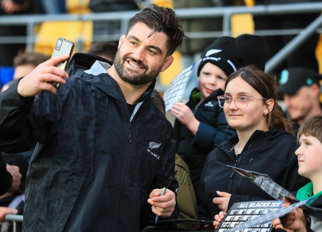 New Zealand's Luke Jacobson (L) takes a selfie with fans after the captain's run training session in Wellington on July 10, 2026, ahead of the rugby Nations Championship match against Italy. (Photo by Grant Down / AFP)