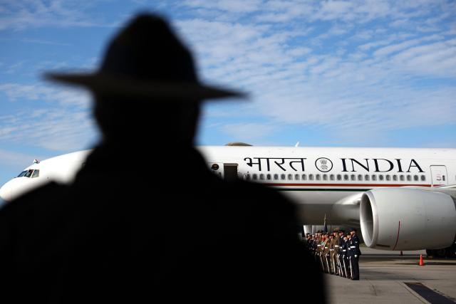 A military personal officer stands with other officials as they await the arrival of Indian Prime Minister Narendra Modi at Melbourne airport on July 10, 2026, as he prepares to leave at the end of an official visit to Australia. (Photo by MARTIN KEEP / AFP)