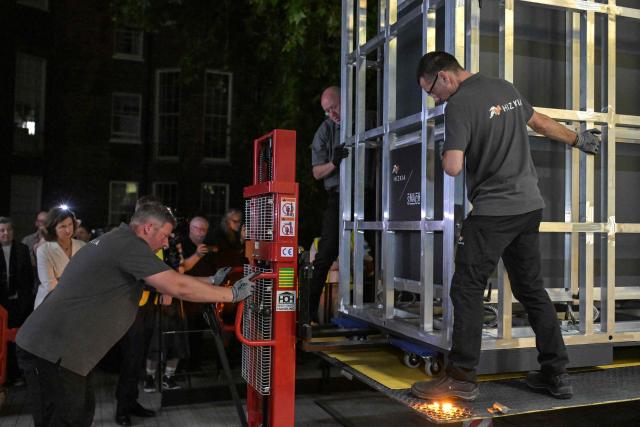 Workers unload a specially designed crate (R) carrying the Bayeux Tapestry at the British Museum in central London early on July 10, 2026, as the 11th-century artwork depicting the 1066 Norman conquest of England arrives ahead its first UK exhibition from September. The medieval Bayeux Tapestry arrived in London in the early hours of July 10, after a hugely complicated journey to leave France for the first time in more than 900 years for an exhibition in the British capital. (Photo by Richard A. Brooks / AFP)
