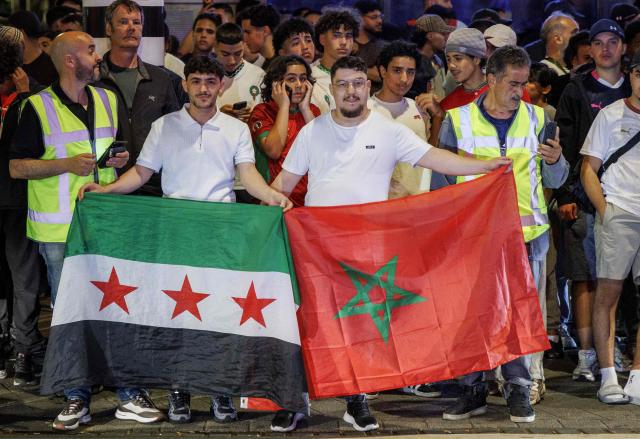Moroccan football fans react in a street waving flags of Syria and Morocco following Morocco's defeat against France in the 2026 World Cup quarter final football match in Amsterdamon July 10, 2026. (Photo by SEBASTIAAN BAREL / ANP / AFP) / Netherlands OUT