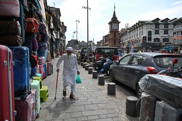 This photograph taken on July 6, 2026 shows a pedestrian walking on a footpath along a road in Srinagar. In India, a pavement can be many things -- hawking site, parking area, garbage dumping space -- but rarely what it is meant to be: a safe unobstructed path to walk on. (Photo by TAUSEEF MUSTAFA / AFP)