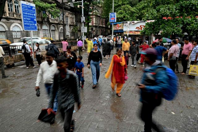 This photograph taken on July 7, 2026 shows pedestrians walking on a footpath in Mumbai. In India, a pavement can be many things -- hawking site, parking area, garbage dumping space -- but rarely what it is meant to be: a safe unobstructed path to walk on. (Photo by Indranil Mukherjee / AFP)