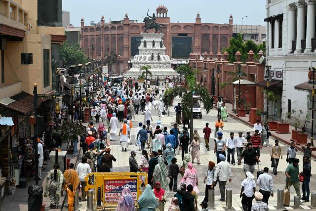 This photograph taken on July 7, 2026 shows pedestrians walking along the heritage street in Amritsar. In India, a pavement can be many things -- hawking site, parking area, garbage dumping space -- but rarely what it is meant to be: a safe unobstructed path to walk on. (Photo by Narinder NANU / AFP)
