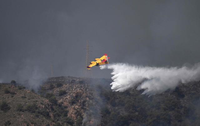 A picture taken on July 10, 2026 shows a Canadair water bombing aircraft on the site of a wildfire that killed 11 near Los Gallardos, in Almeria Province. Eleven people were killed and 19 are missing after a wildfire in Bedar, in Los Gallardos district, with four victims who may have been British who were burned in their car, authorities said. (Photo by JOSE JORDAN / AFP)
