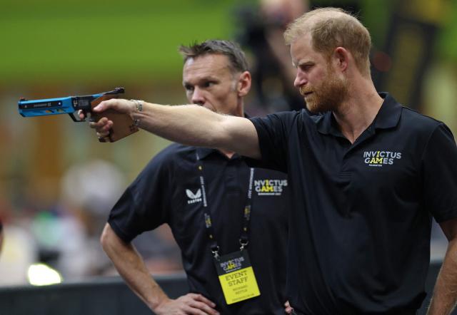 Britain's Prince Harry, Duke of Sussex, holds a Laser Pistol as he takes part in the shooting aspect of Laser Run, during an event to mark the 'Invictus Games Birmingham 2027: One Year To Go', at the NEC in Birmingham, central England on July 10, 2026. (Photo by Darren Staples / AFP)