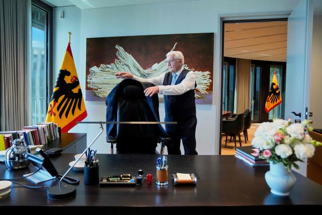 German President Frank-Walter Steinmeier poses for photos at his desk as he welcomes media representatives on his first day at his new presidential office while the presidential Bellevue Palace undergoes renovation in Berlin, Germany, on July 10, 2026. (Photo by Ebrahim Noroozi / POOL / AFP)
