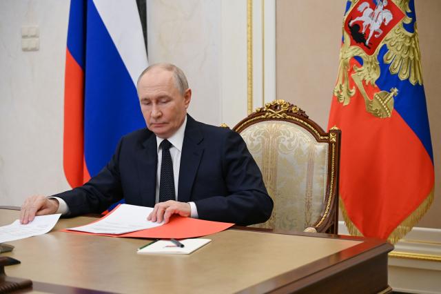 In this pool photograph distributed by the Russian state agency Sputnik, Russia's President Vladimir Putin chairs a Security Council meeting via videolink in Moscow on July 10, 2026. (Photo by Pavel Byrkin / POOL / AFP)