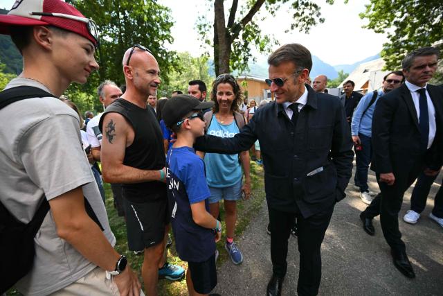 France's President Emmanuel Macron (R) speaks with a child as he visits sports facilities in Loudenvielle, south-western France, on July 10, 2026. (Photo by Lionel BONAVENTURE / POOL / AFP)