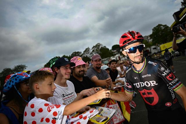 Tudor Pro Cycling Team's French rider Julian Alaphilippe signs autographs as he awaits the start of the 7th stage of the 113th edition of the Tour de France cycling race, 175 km between Hagetmau and Bordeaux in southwestern France, on July 10, 2026. (Photo by Loic VENANCE / AFP)