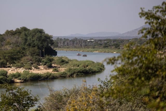 People travel aboard makeshift boats across the Limpopo River along the South Africa-Zimbabwe border near the Beitbridge border crossing on July 9, 2026, while crossing the border outside the official port of entry. Several thousands more foreign nationals clamoured to leave South Africa on July 3, many of them gathered near the Zimbabwe border after a push that has already seen around 35,000 go home. The exodus began weeks ago as fringe groups began demanding all illegal migrants leave by June 30, in a campaign that saw violent protests and clashes. Thousands of foreigners awaited the journey home inside sprawling white tarpaulin tents serving as a temporary repatriation centre after fleeing deadly anti-immigrant protests in South Africa. More than 21,000 people had been housed and processed at the facility, according to its manager, Limpopo provincial Home Affairs chief Albert Matsaung. (Photo by EMMANUEL CROSET / AFP)