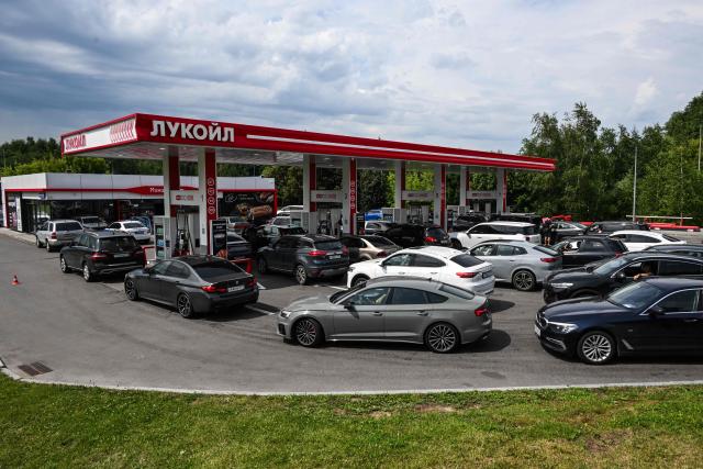 People queue to refuel their cars at a Lukoil petrol station in Moscow on July 10, 2026. Russia -- one of the world's largest oil producers -- has introduced a swath of restrictions on petrol sales across the country, as Ukrainian strikes on its refineries, depots and logistics crimp domestic supply. Several regions have introduced rationing, while some gas stations and chains have sold out or closed due to a lack of supplies. (Photo by Igor IVANKO / AFP)