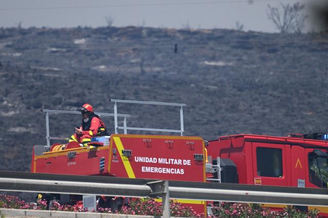 A firefighter is pictured on a Military Emergency Unit (UME) vehicle in a burnt landscape in the area of a wildfire that killed 11 near Bedar, in Los Gallardos district, in Almeria Province, on July 10, 2026. Eleven people were killed and 19 are missing after a wildfire tore through a Spanish village, with four victims who may have been British who were burned in their car, authorities said. (Photo by JOSE JORDAN / AFP)