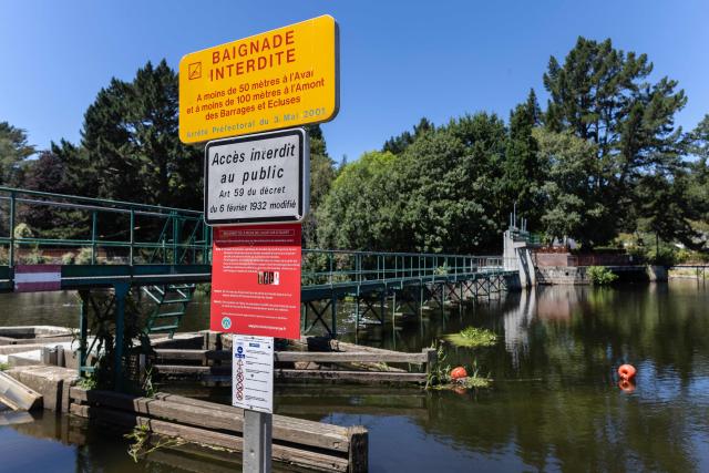 (FILES) This photograph shows a panel reading "Swimming forbidden" near a lock on the River Blavet at Hennebont, western France on July 6, 2026. France's Sports and Youth Minister announced on July 10, 2026, that 131 people have died from drowning since June 19, specifying that many of the victims were either "under 18 years of age" or "over 60 years old". (Photo by Fred TANNEAU / AFP)