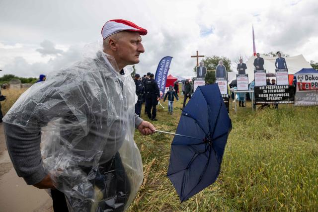 A man holds an umbrella at a gathering of far-right supporters who question the guilt of the Polish citizens responsible for the massacre in Jedwabne and place all the blame on the German pacification unit, on the sidelines of the official ceremonies at the Jedwabne massacre monument honouring the memory of the town's Jewish residents murdered on July 10, 1941 by their Polish neighbours, in Jedwabne, north-eastern Poland, on July 10, 2026. Poland's Jewish community, political leaders and ordinary citizens on July 10 commemorated a massacre of hundreds of Jews killed by their Polish neighbors 85 years ago in the town of Jedwabne in then German-occupied Poland, at a ceremony opposed by far-right demonstrators. (Photo by Wojtek RADWANSKI / AFP)