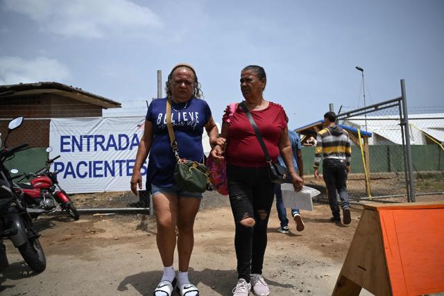 Women exit the US Samaritan's Purse field hospital in La Guaira, Venezuela on July 10, 2026, following the June 24 twin earthquakes. Venezuela's devastating earthquake threatens to set back momentum for a democratic transition, with the United States under President Donald Trump even more set on prioritizing stability over elections. (Photo by Raul ARBOLEDA / AFP)