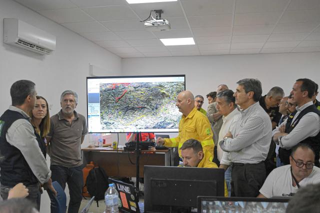 Spain's Interior Minister Fernando Grande-Marlaska (3L) and the Secretary General of Civil Protection and Emergencies Virginia Barcones (2L) visit the advanced command post of the Los Gallardos fire in Turre, in Almeria Province, on July 10, 2026 in the aftermath of a wildfire that killed 12. Twelve people were killed and 23 are missing after a fast-moving wildfire tearing through area in southern Spain, home to many foreign residents. Spain has been sweltering in extreme heat, creating tinderbox conditions favourable for the rapid spread of wildfires. (Photo by Jose JORDAN / AFP)