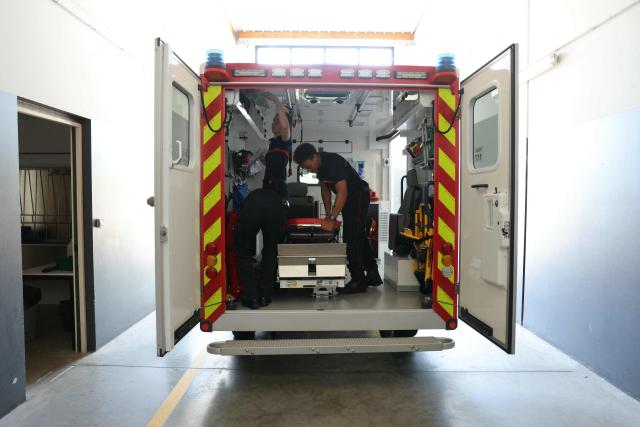 Firefighters of Departmental Fire and Rescue Service (SDIS 77) gear up an ambulance at a fire station in Ferrières-en-Brie, the eastern suburbs of Paris, on July 10, 2026. With 36°C in the fire station and some improvised DIY solutions, firefighters are also suffering from the heatwave hitting France. (Photo by Thomas SAMSON / AFP)
