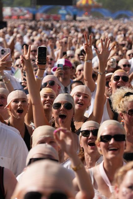 Members of the crowd sporting "bald caps" gather in the sunshine ahead of a concert by US rapper and singer Pitbull in Hyde Park, London, on July 10, 2026. Ahead of the performance an official GUINNESS WORLD RECORDS title attempt for the 'largest gathering of people wearing bald caps' will be held. (Photo by CARLOS JASSO / AFP)