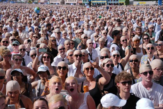 Members of the crowd sporting "bald caps" gather in the sunshine ahead of a concert by US rapper and singer Pitbull in Hyde Park, London, on July 10, 2026. Ahead of the performance an official GUINNESS WORLD RECORDS title attempt for the 'largest gathering of people wearing bald caps' will be held. (Photo by CARLOS JASSO / AFP)