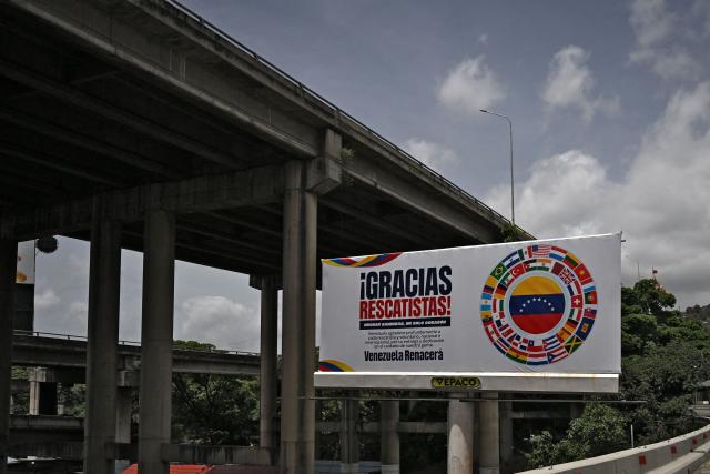 View of a sign reading "Thank you rescuers!" on a highway in Caracas on July 10, 2026, following the June 24 twin earthquakes. The death toll from the powerful double earthquake that struck Venezuela two weeks ago has risen to at least 3,889, whilst the number of injured remains at almost 17,000, according to an official government report released on July 9, 2026. The powerful consecutive earthquakes, measuring 7.2 and 7.5 on the Richter scale on 24 June, also left 17,907 people homeless, according to the report released by the Speaker of Parliament, Jorge Rodriguez, on Telegram. (Photo by Raul ARBOLEDA / AFP)