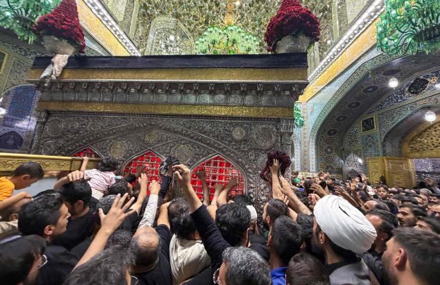 Pilgrims visit the shrine of Imam Reza after the funeral of slain Iranian leader Ali Khamenei and his family members in Mashhad on July 10, 2026. Iran on July 10 laid to rest its former supreme leader Ali Khamenei over four months after his killing in an airstrike, as two days of US and Iranian attacks raised fears of a return to all-out war. (Photo by ATTA KENARE / AFP) / 