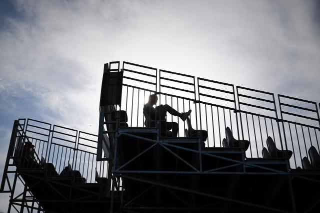 A festivalgoer waits on the grandstand ahead of the first concerts on the opening day of the 42nd Francofolies music festival in La Rochelle, western France, on July 10, 2026, as France endures a heatwave. (Photo by Philippe LOPEZ / AFP)