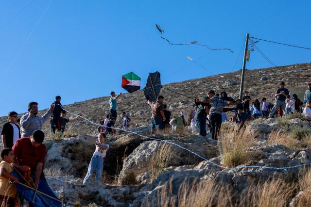 Palestinians and solidartiy activists fly kites towards the Israeli settelment of Har Bracha from the village of Burin, south of Nablus in the occupied West Bank on July 10, 2026. (Photo by Jaafar ASHTIYEH / AFP)