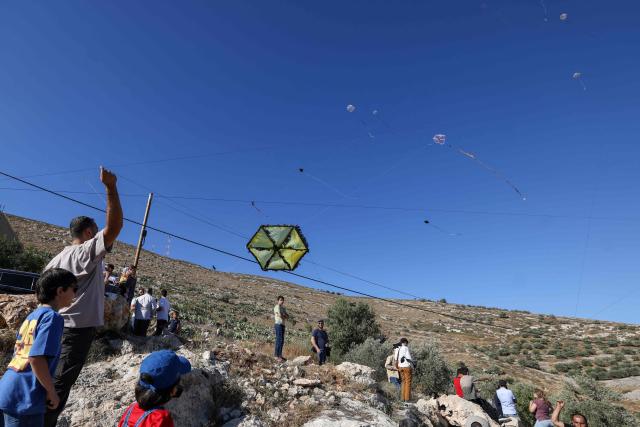 Palestinians and solidartiy activists fly kites towards the Israeli settelment of Har Bracha from the village of Burin, south of Nablus in the occupied West Bank on July 10, 2026. (Photo by JAAFAR ASHTIYEH / AFP)