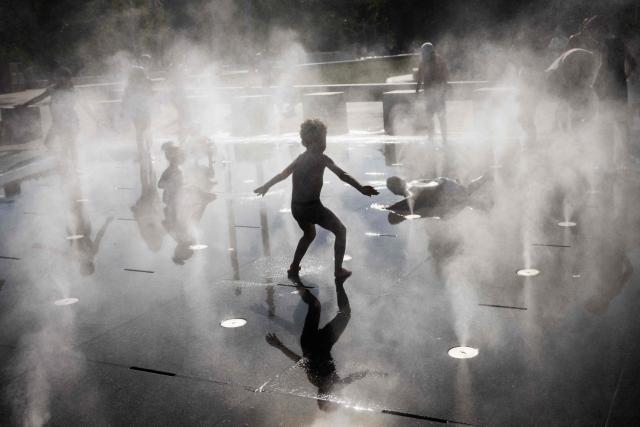 Children play in a splash pad during a heatwave in Paris on July 10, 2026. (Photo by Behrouz MEHRI / AFP)