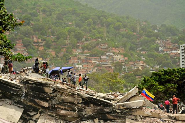 Rescue workers and relatives of missing people look for victims, in Caraballeda, state of La Guaira, Venezuela, on July 10, 2026, following the June 24 twin earthquakes. The death toll from the powerful double earthquake has risen to at least 3,889, whilst the number of injured remains at almost 17,000, and nearly 18,000 people were left homeless according to the last official reports. (Photo by MARTIN BERNETTI / AFP)