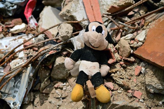 This image shows a plush Mickey Mouse amid rubble in the site of a collapsed building in Caraballeda, state of La Guaira, Venezuela, on July 10, 2026, following the June 24 twin earthquakes. The death toll from the powerful double earthquake has risen to at least 3,889, whilst the number of injured remains at almost 17,000, and nearly 18,000 people were left homeless according to the last official reports. (Photo by MARTIN BERNETTI / AFP)