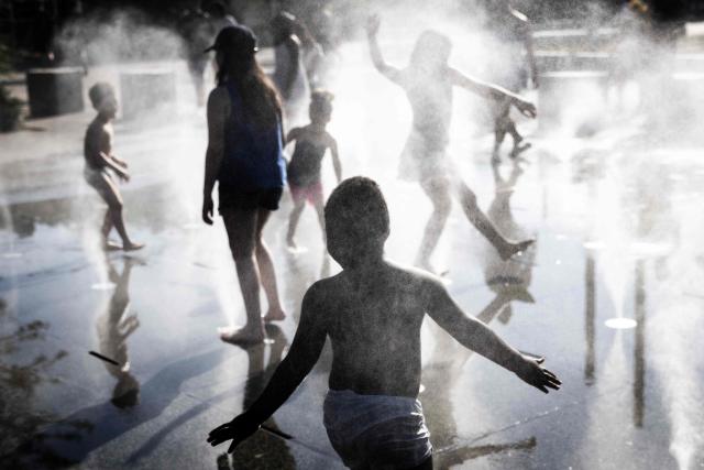 Children play in a splash pad during a heatwave in Paris on July 10, 2026. (Photo by Behrouz MEHRI / AFP)