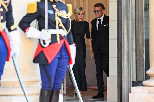 France's President Emmanuel Macron (R) and his wife Brigitte Macron arrive to greet South Africa's President at the Elysee Presidential Palace ahead of an official state dinner in Paris on July 10, 2026. (Photo by JULIEN DE ROSA / AFP)